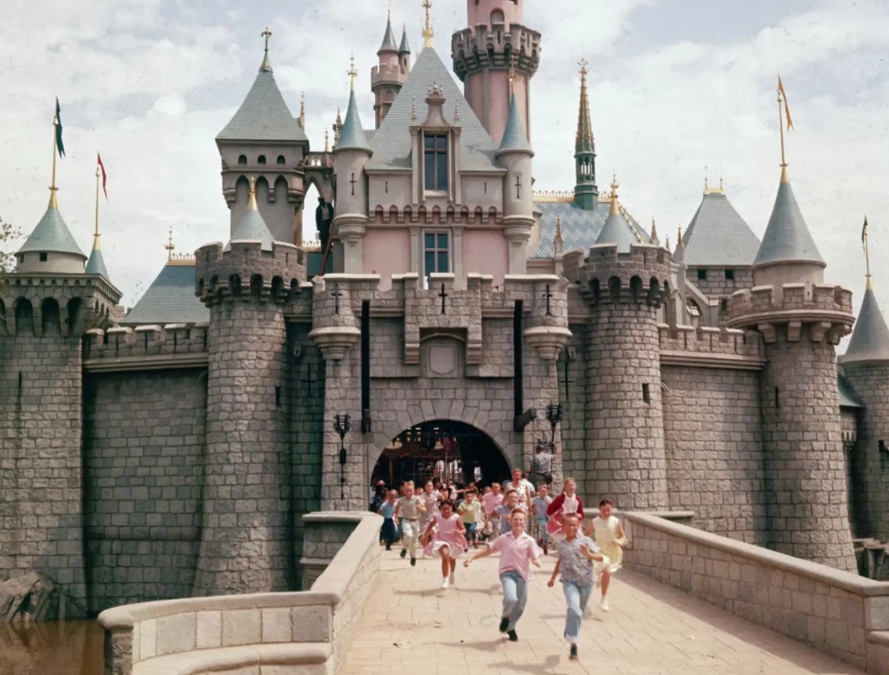 Children running across the drawbridge of Sleeping Beauty Castle at Disneyland